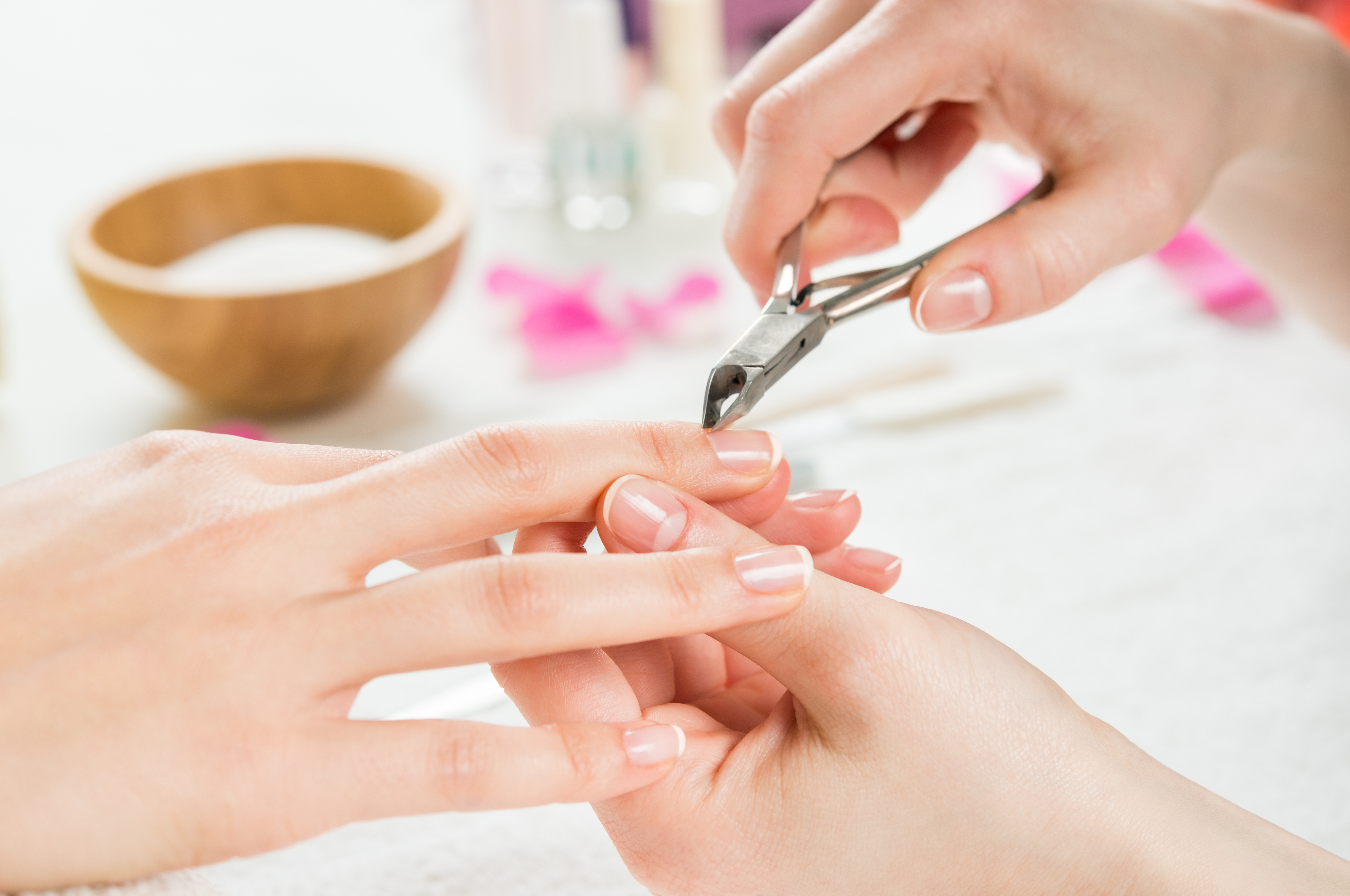 Close-up of a manicure session with nail technician trimming cuticles.